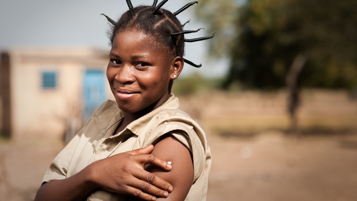 A woman holding a cotton ball against her arm after a vaccination injection.