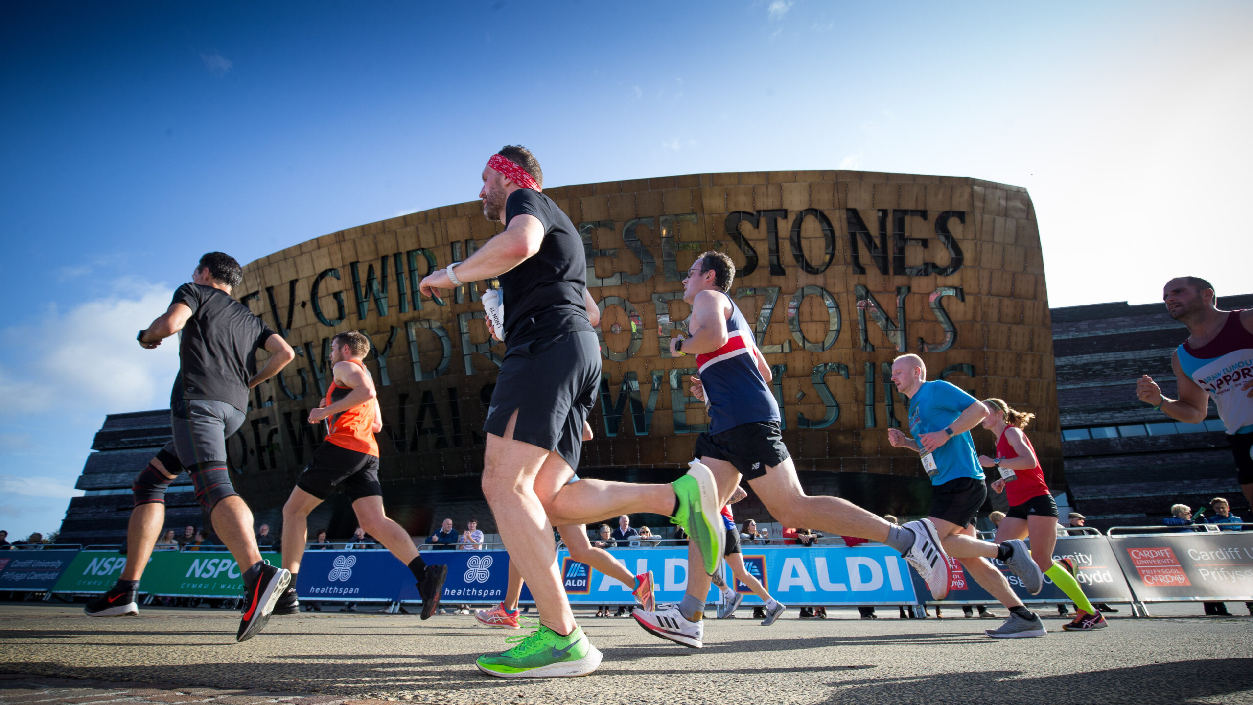 Runners make their way past the Wales Millennium Centre at the halfway point of the race.