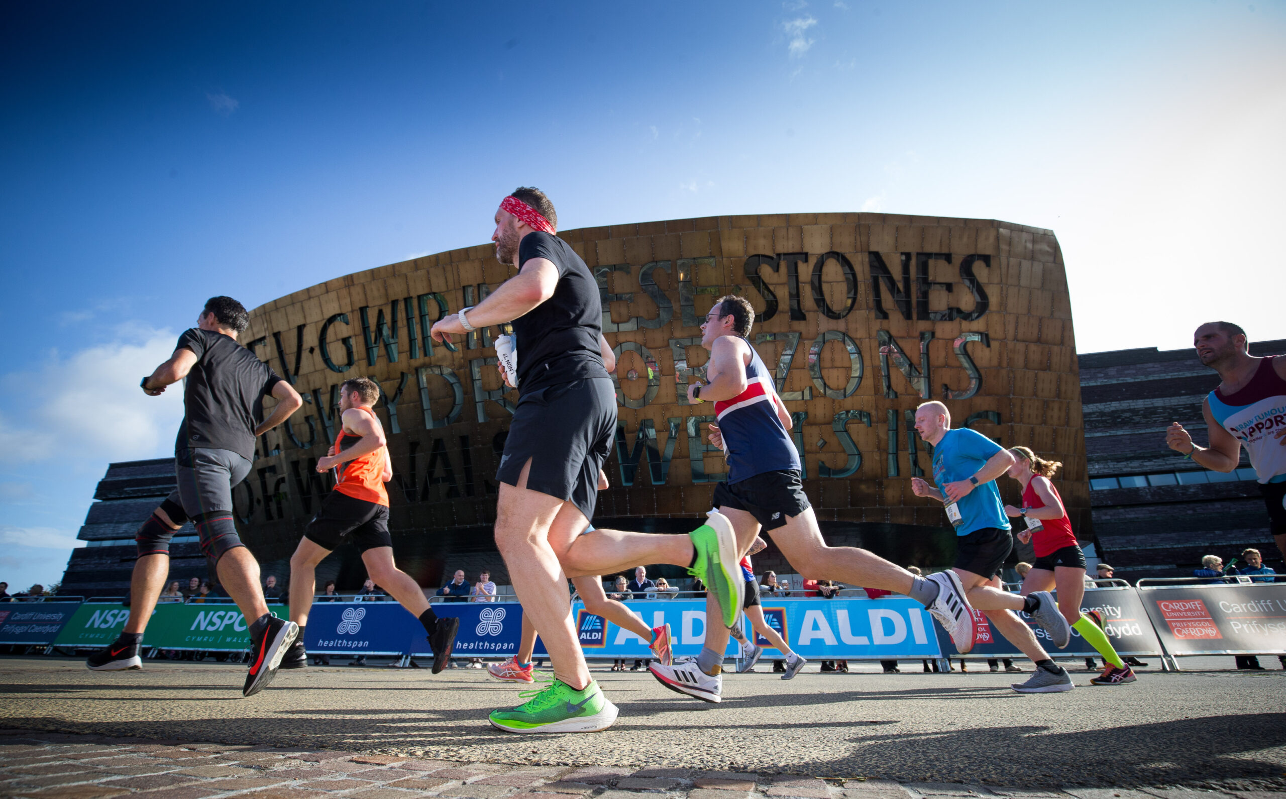 Runners make their way past the Wales Millennium Centre at the halfway point of the race.