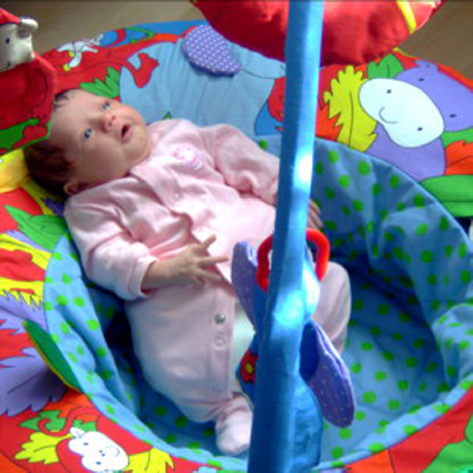 Baby Amber Rose Harris lying on a play mat