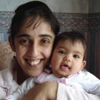 A photograph of Jasvinder holding baby Amrit and smiling