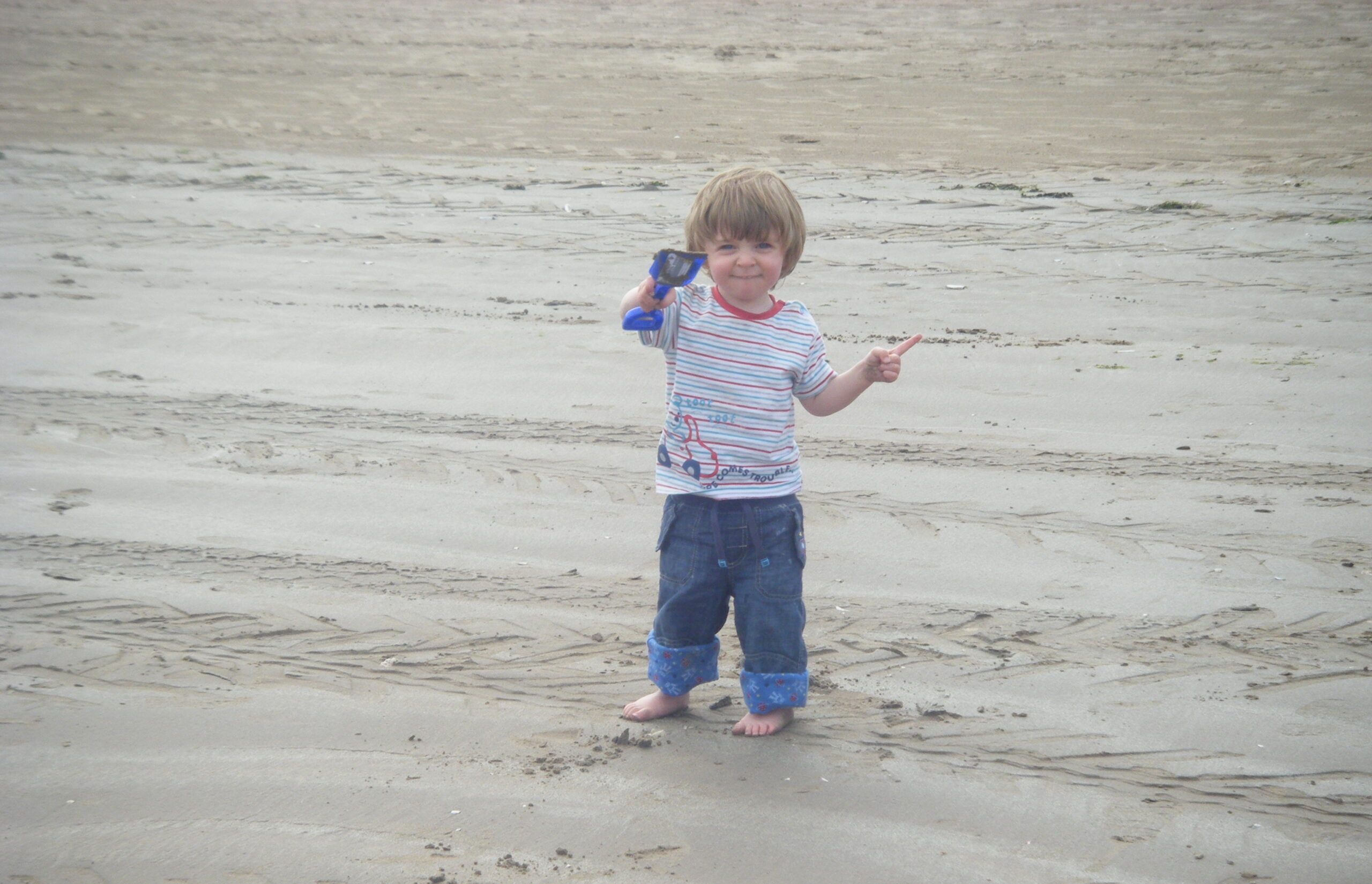A photograph of Ben as a toddler on the beach