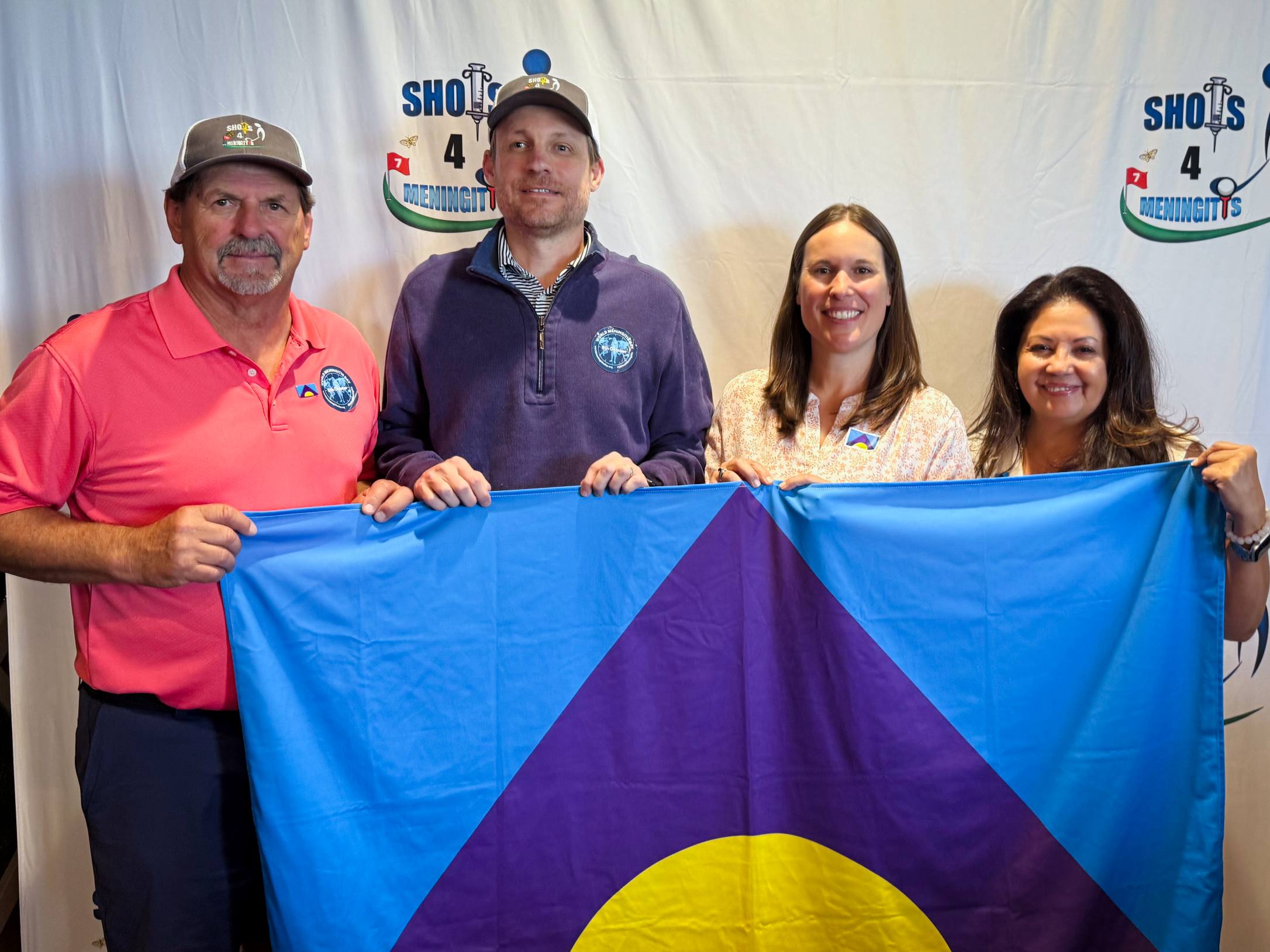 Bob, John, Patsy, Heather Entemann (Sanofi), holding a meningitis flag at a shots 4 meningitis event.
