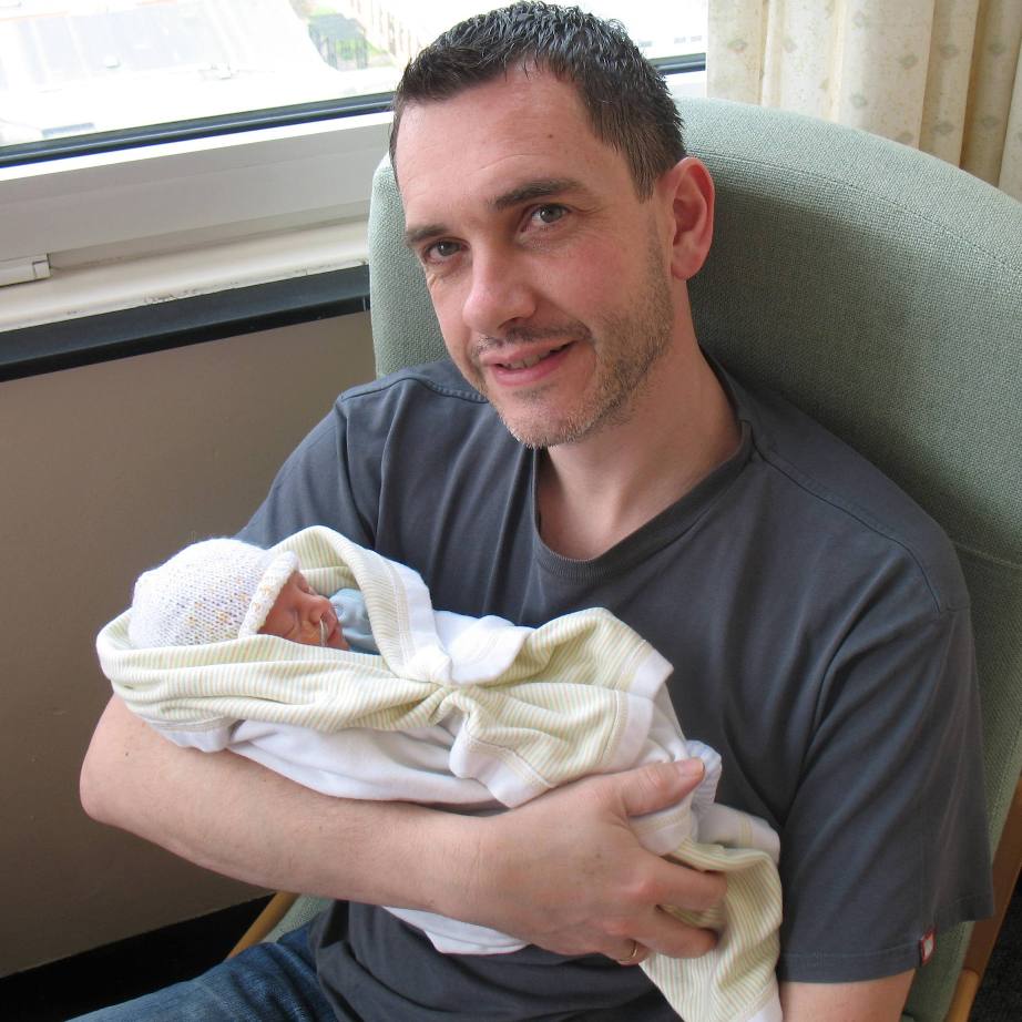 A photograph of Cayden's father holding him as a baby