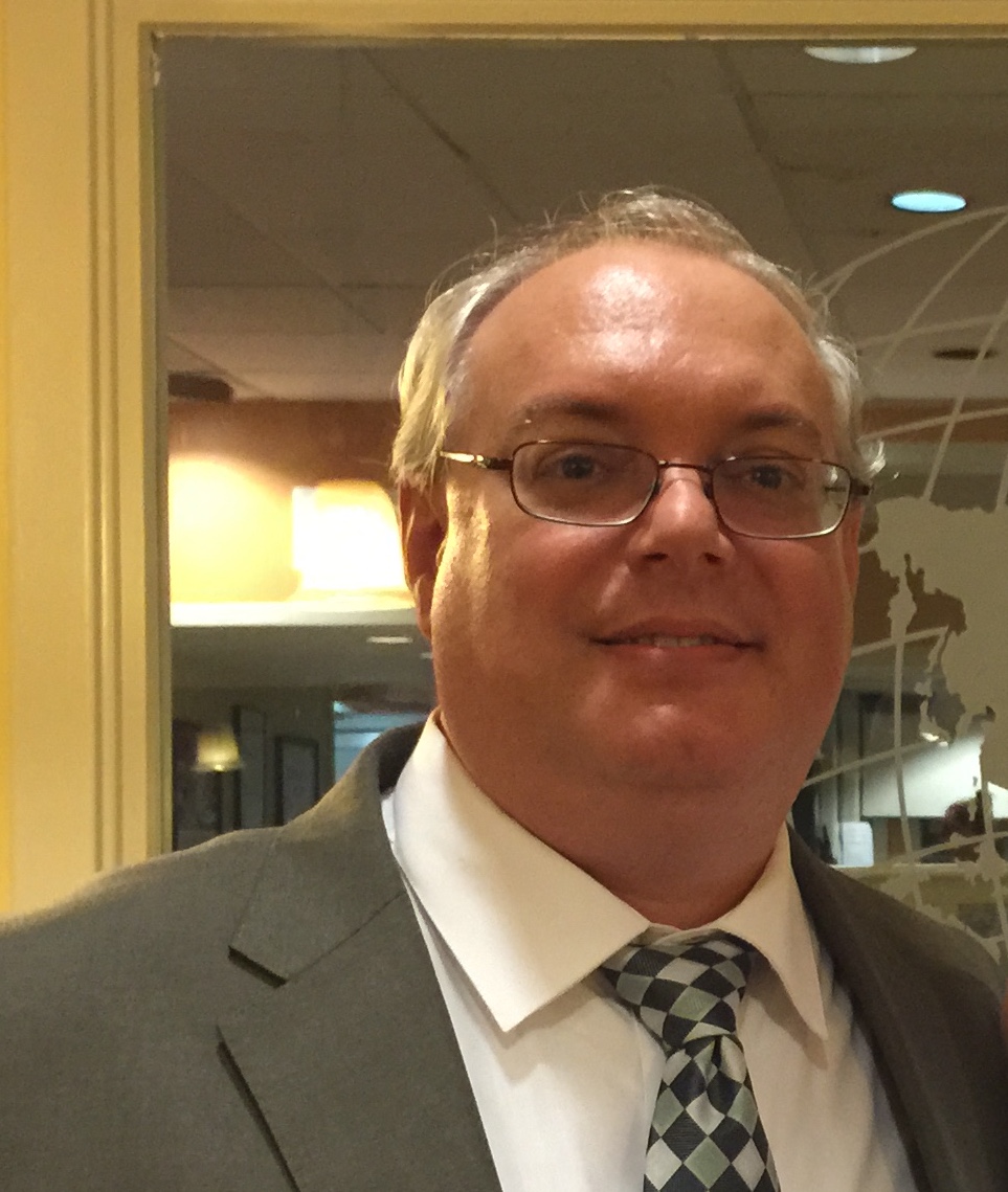 A photograph of Christopher Sellers wearing a suit