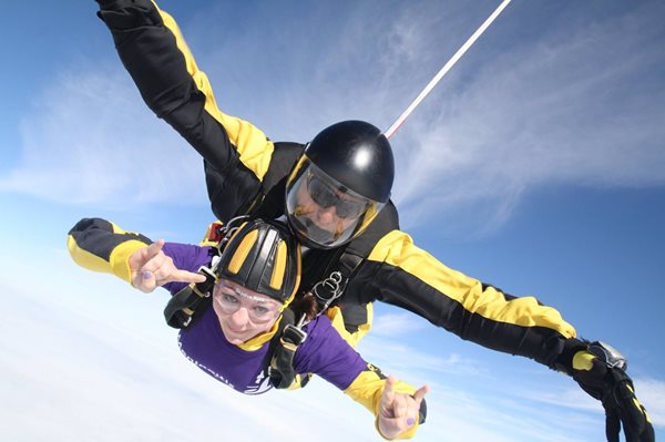 Two people are falling through the air in a tandem skydive.