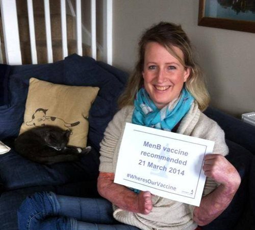 A photograph of Diana Man holding a sign that reads' Men B vaccine recommended 21 March 2014'