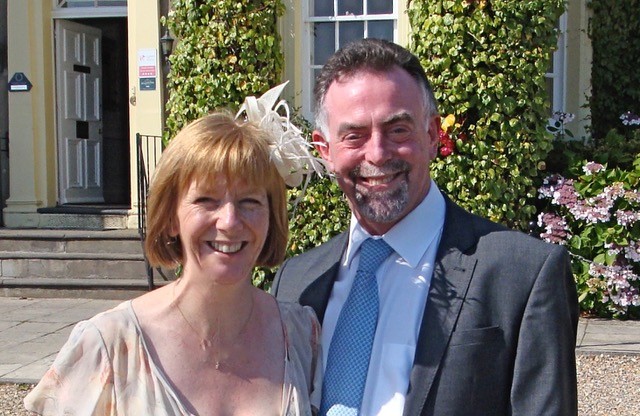 Image of Diane and her late husband John who are both smiling and wearing formal occasion clothes