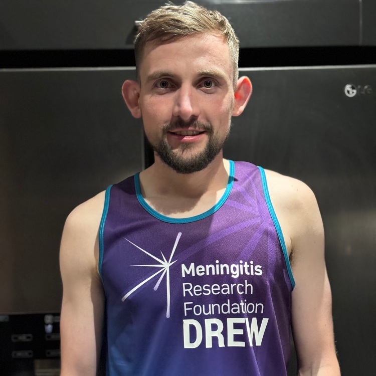 Drew Darlington wearing Meningitis Research Foundation running vest