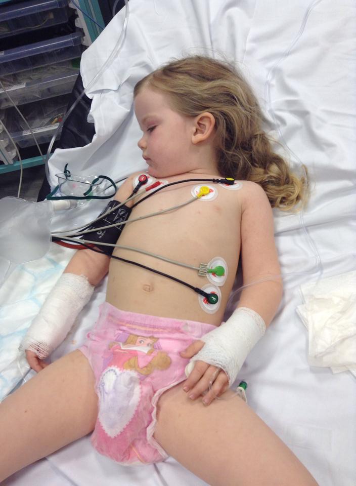 A photograph of Eloise Carter in a hospital bed with lots of tubes attached