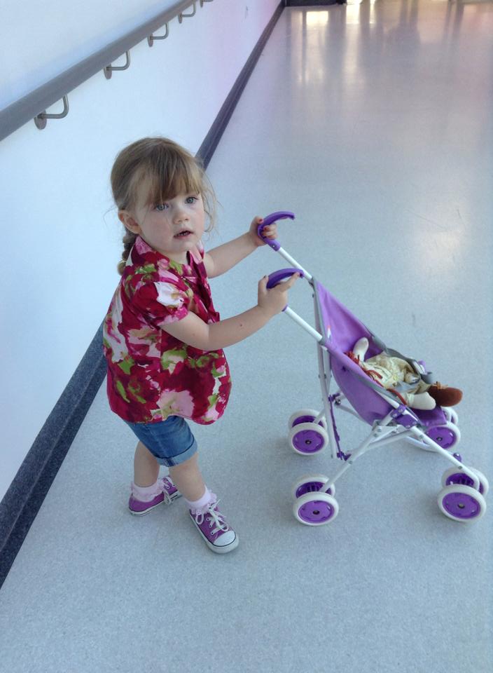 A photograph of Eloise Carter holding a toy pram.