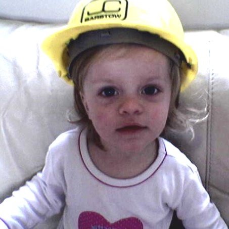 A photograph of Freya wearing a yellow workman's helmet
