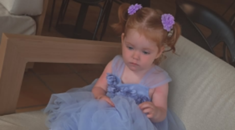 Young girl in blue dress sat on a chair