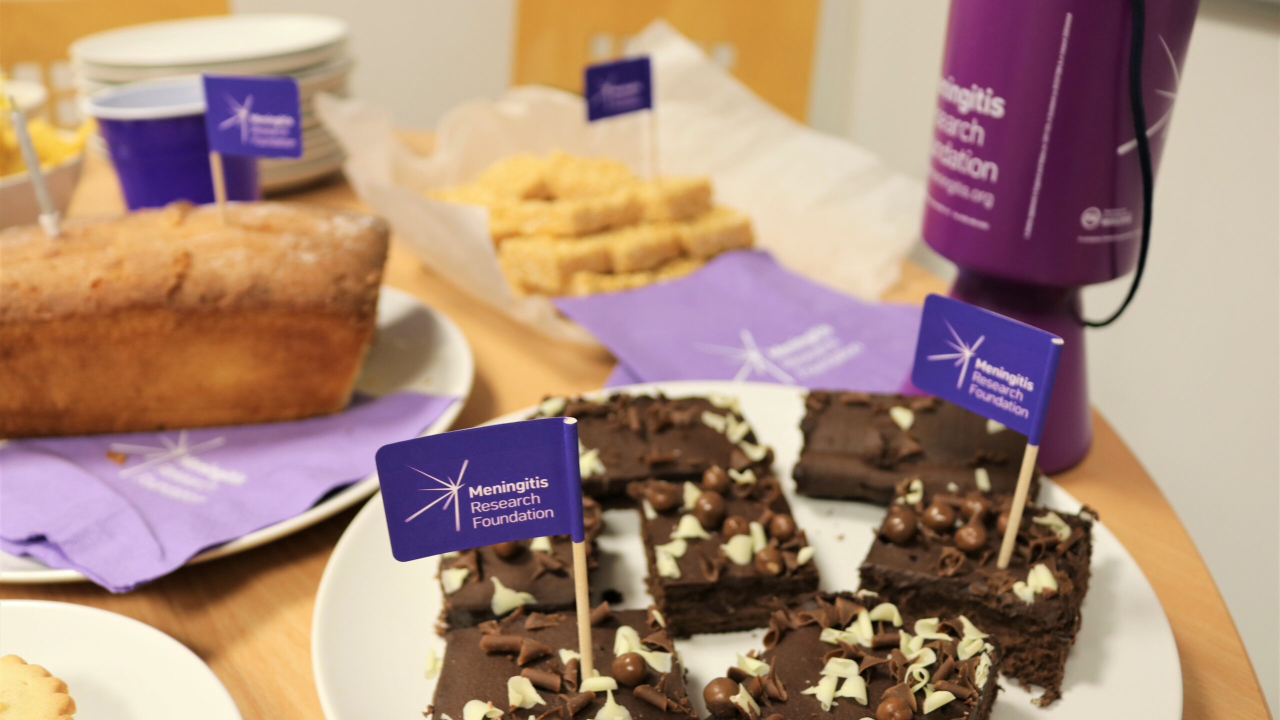 Cakes on table with Meningitis Research Foundation flags.