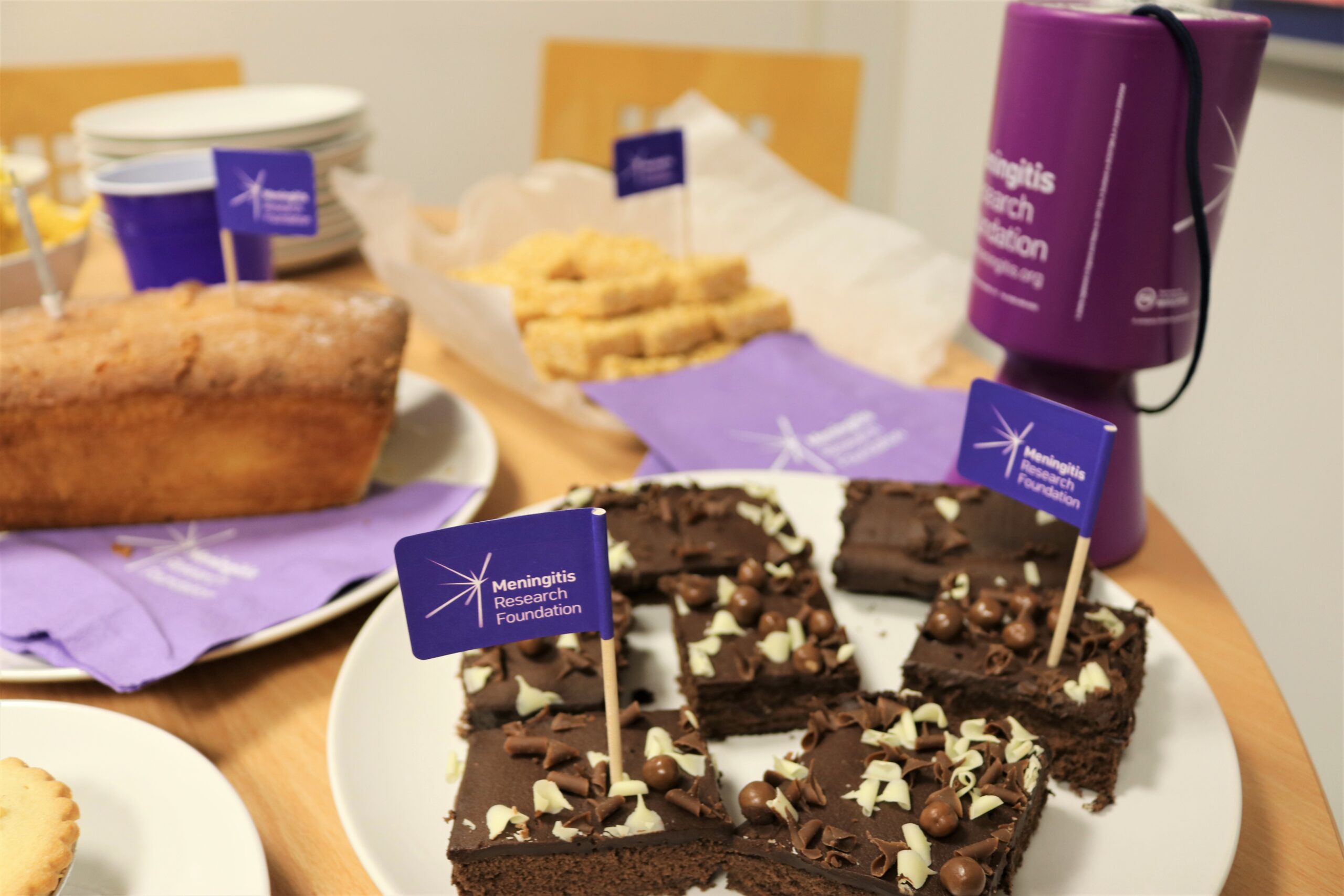 Cakes on table with Meningitis Research Foundation flags.