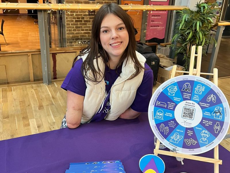 Isabelle Weall smiling wearing a Meningitis Research Foundation t-shirt
