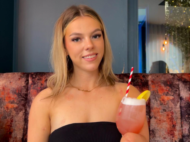 Isabelle Weall smiling holding a cocktail