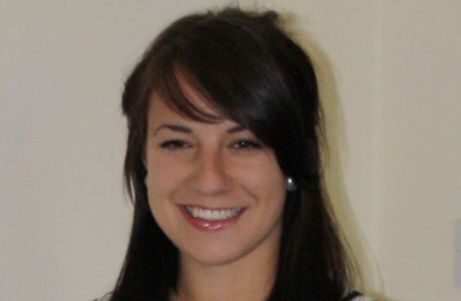 A young woman with brown hair smiling.