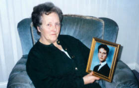 Kathleen Mills holding a photograph of her son, David