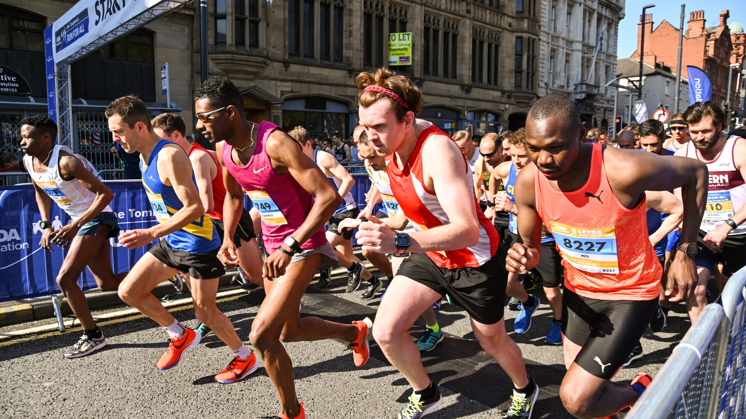 Group of runners setting off from the race start line.