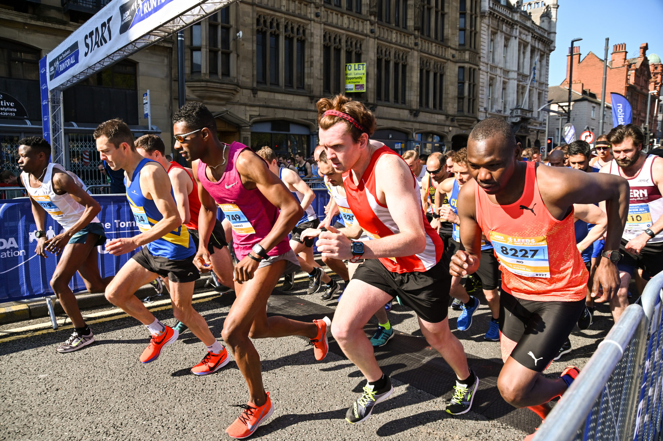 Group of runners setting off from the race start line.