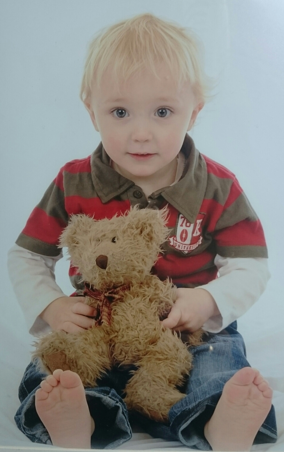 A photographic portrait of Leo Wells holding a teddy bear