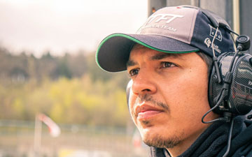 Ludovic Peze wearing a headset and headphones and a cap
