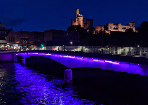 Ness bridge at night illuminated with purple lighting