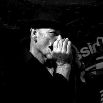 A black and white photograph of Paul Tidiman singing