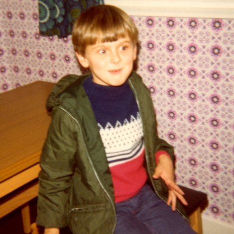 A photograph of a child wearing a jumper and coat