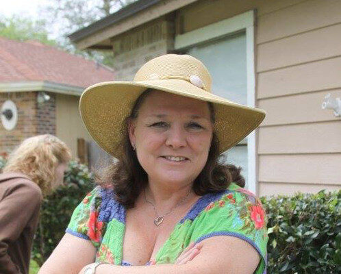 A photograph of Robin Owens outdoors wearing a sunhat