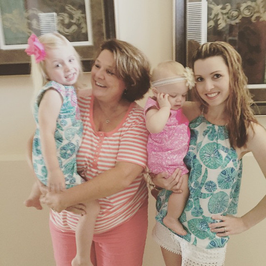 Two women holding young girls