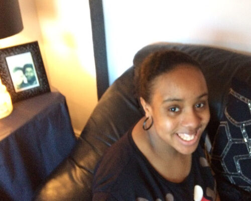 A photograph of Robyn Jackson sitting on a couch