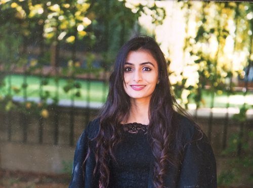 A photograph of Shirali Patel outdoors wearing black.