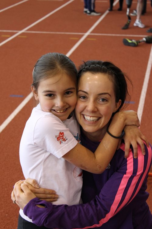 Sofia Crockatt and Stef Reid embracing on a running track