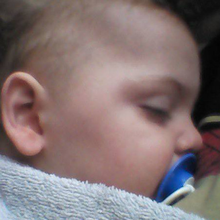 A photograph of baby Travis sleeping with a dummy in his mouth