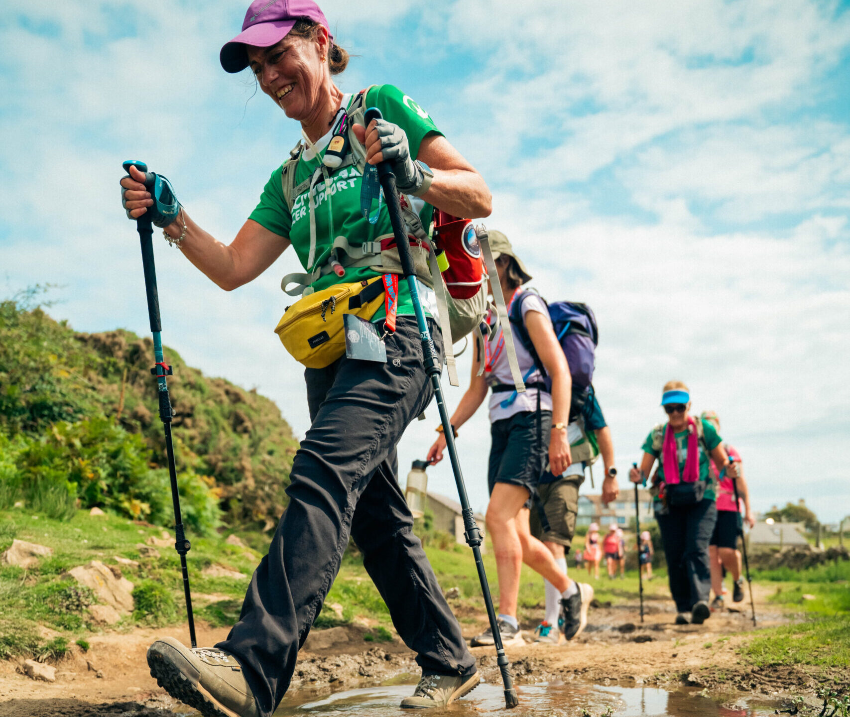 Hikers make their way along a muddy track.
