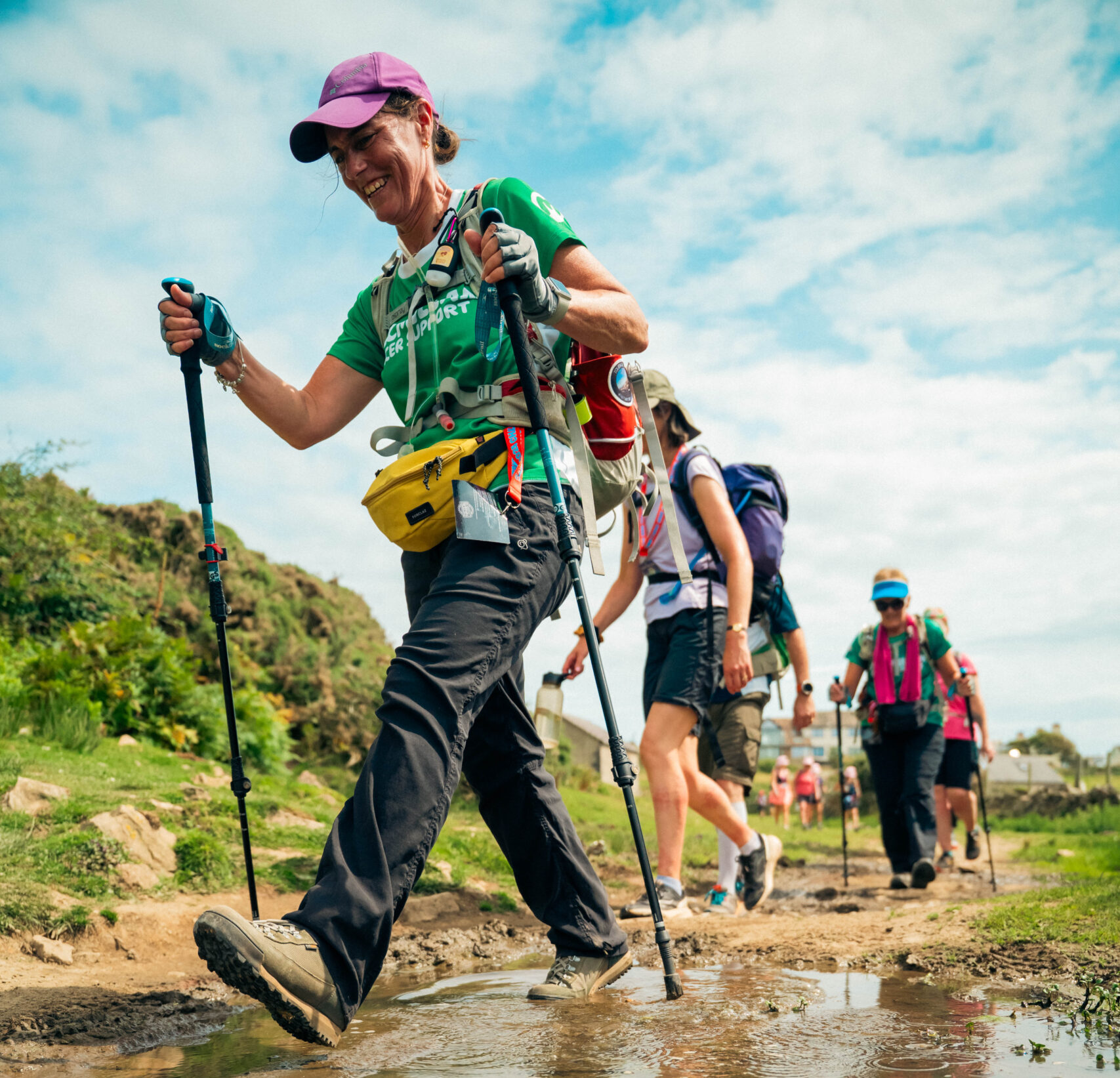 Hikers make their way along a muddy track.