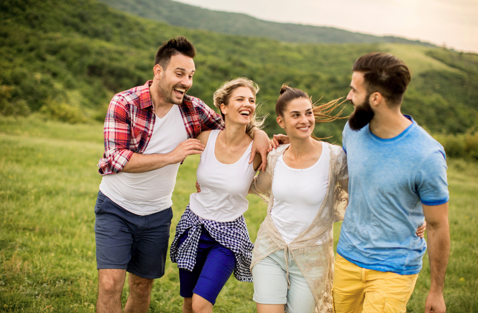 Young people smiling on a field.