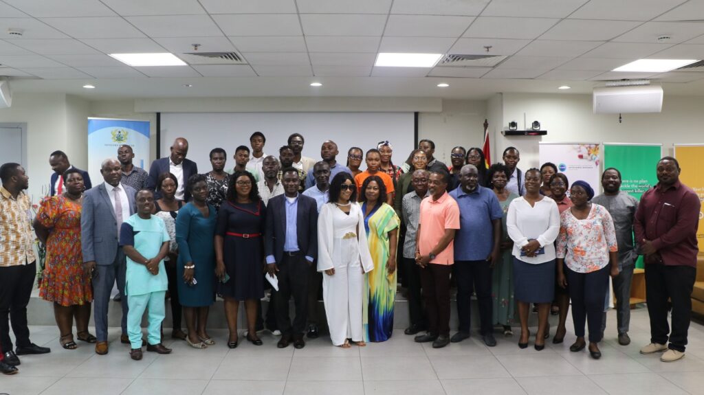 Group of people stood inside, smiling for a group photo