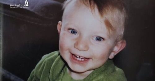 A young boy with brown hair and blue eyes smiling.