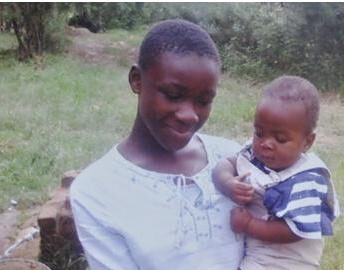 A photograph of baby Praise being held by a relative