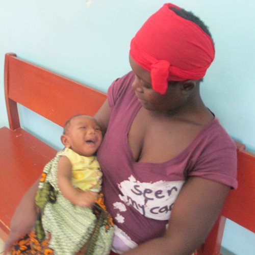 A photograph of Faith being held by a woman