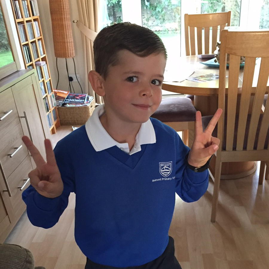 A photograph of Luke in his school uniform giving peace signs