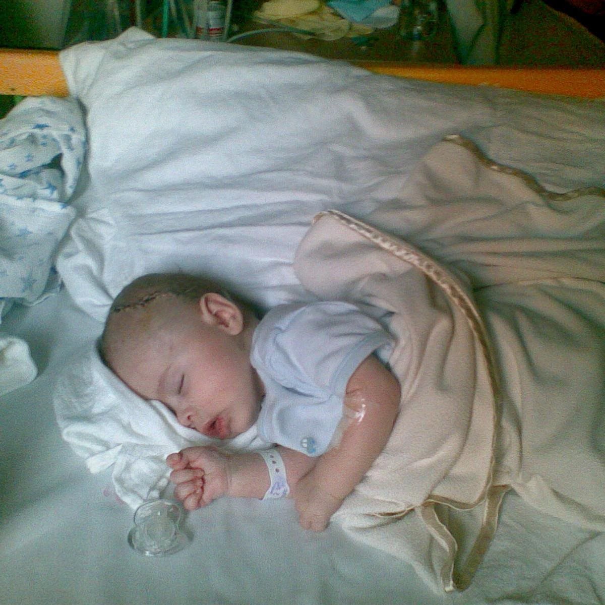 A photograph of baby Luke in a hospital bed