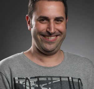 A photograph of a man smiling at the camera