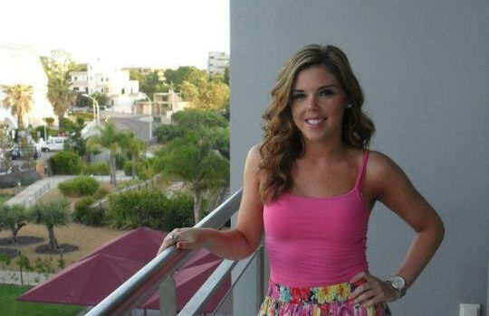 A photograph of Nikki Craig on a balcony in summer clothes
