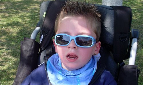 A photograph of Zak in a wheelchair