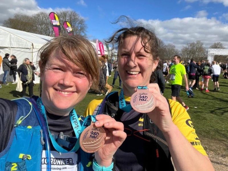 Claire Wright and her partner Tara smiling holding their medals after London Marathon