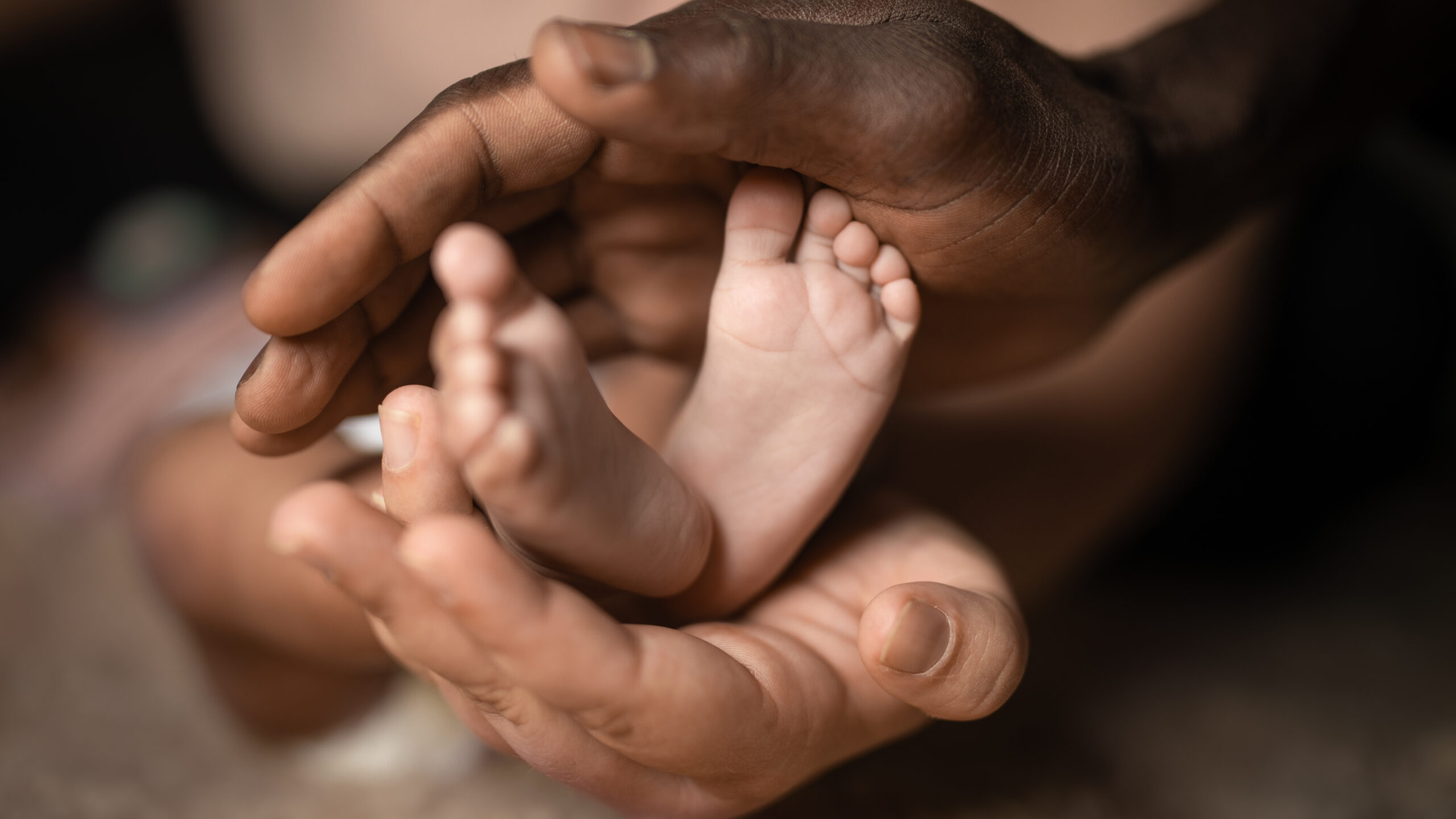 Hands cupping a baby's feet.